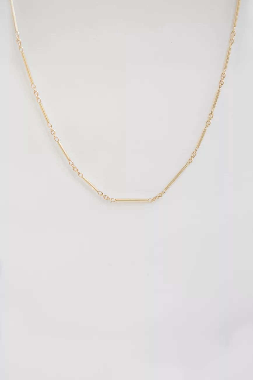 Yellow gold tube chain necklace worn on neck Celine Daoust